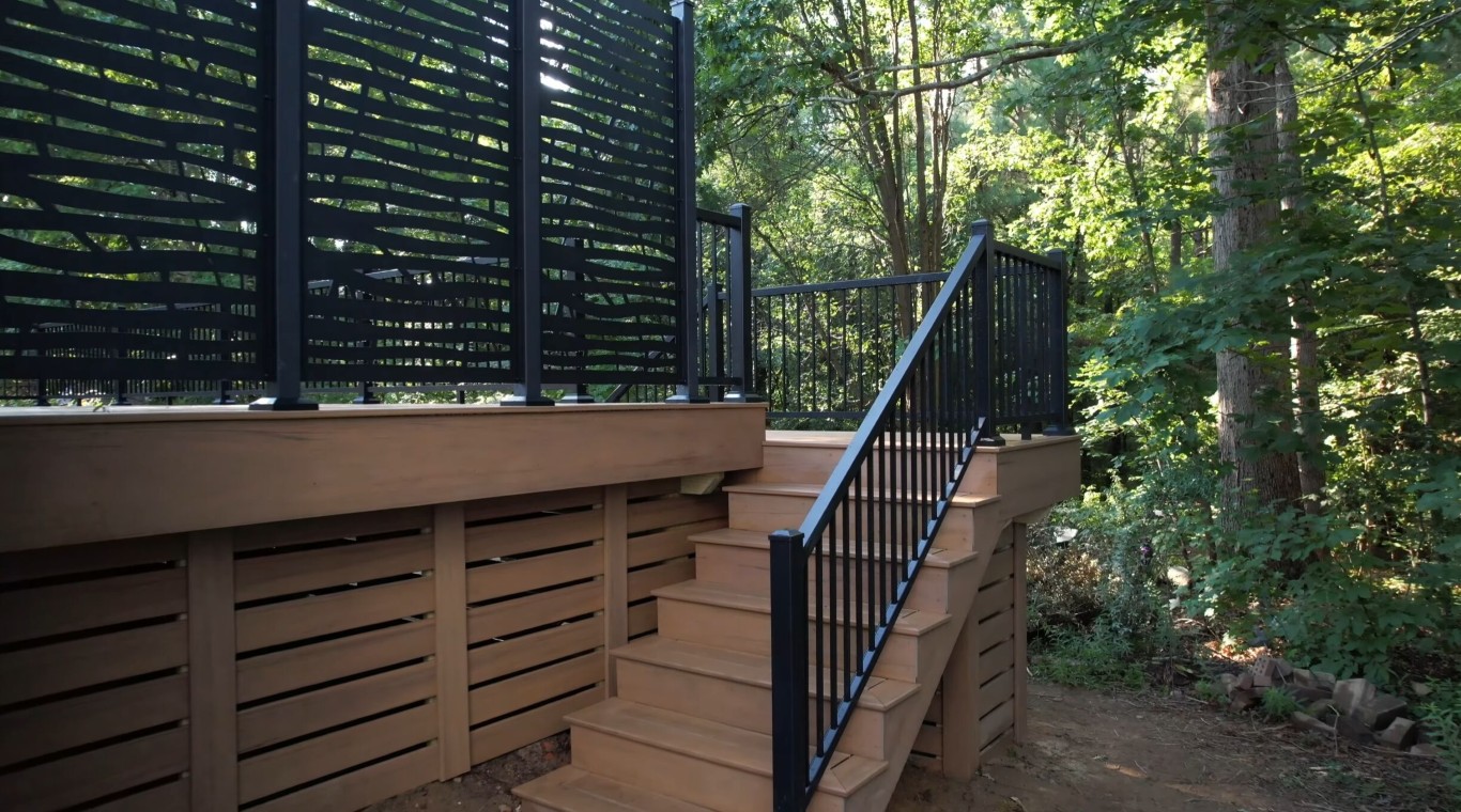 Deck stairs with privacy screen and black railings installed by professional deck builders